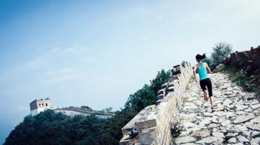 Female athlete cross country running on the Chinese great wall.