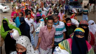 ঢাকায় একটি এলাকায় সাহায্য নিয়ে বাড়ি ফিরছে নিম্ন আয়ের মানুষ।