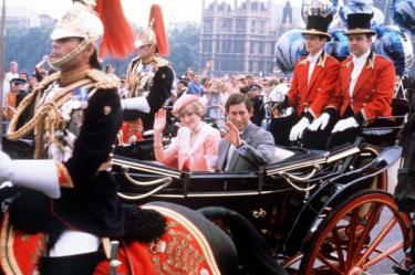 The newly married Prince and Princess of Wale wave to the London crowds from their open-top carriage as they make their way to Waterloo Station to depart for their honeymoon.