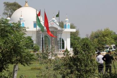 Members of the police forensic unit (R) survey the scene outside the Sufi shrine on the outskirts of Sargodha, Pakistan on 2 April, 2017