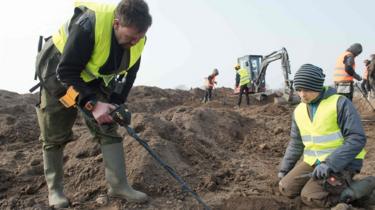Amateur archaeologist Rene Schoen (L) e o estudante Luca Malaschnichenko de 13 anos de idade procuram um tesouro com um detector de metais em Schaprode, norte da Alemanha, a 13 de Abril, 2018