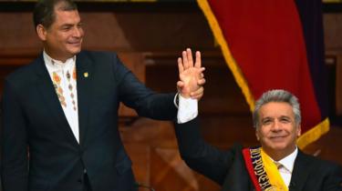 Ecuadorean outgoing President Rafael Correa (L) raises Ecuadorean new President Lenin Moreno's hand at the National Assembly in Quito on 24 May 2017, during Mr Moreno's inauguration ceremony
