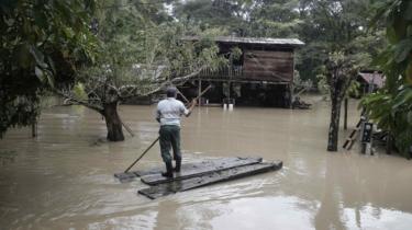 Ein Mann in einem improvisierten Kanu erreicht sein überflutetes Haus in Upala, San Carlos, Costa Rica