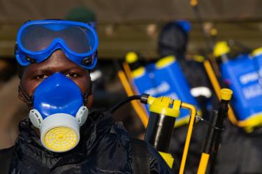 A soldier prepares equipment to spray crops