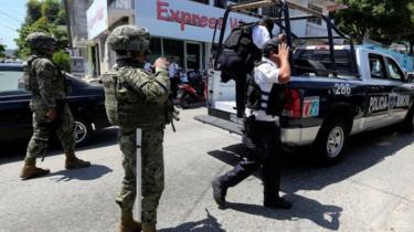 Mexican Marines escort municipal police officers disarmed and detained on suspicion they colluded with organised crime, in Acapulco. Sept 2018