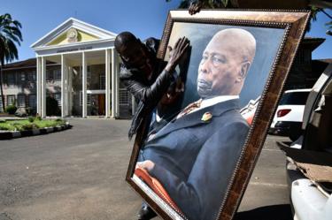 Een man die een portret vasthoudt van wijlen de voormalige president van Kenia, Daniel arap Moi