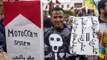 A Moroccan protester holds a banner reading in Arabic "20-year sentence = 20-years injustice"