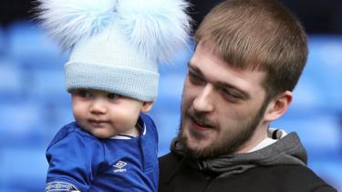  Tom Evans tient son nouveau fils dans un strip d'Everton 