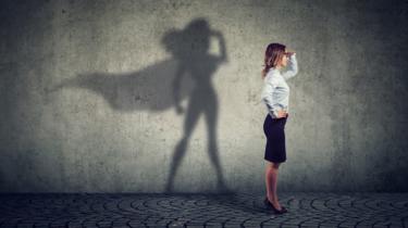 Concept image - Side view of a business woman imagining to be a super hero.