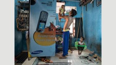 Rizwan Shaikh dan anak perempuannya di rumah mereka di permukiman kumuh Wadala di Mumbai, India; dia berharap anak perempuannya yang berusia tiga tahun, Zafinah, akan menjadi dokter.