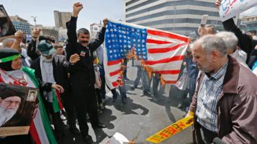 iranska demonstranter bränner en målad amerikansk flagga vid ett möte i Teheran den 10 maj 2019