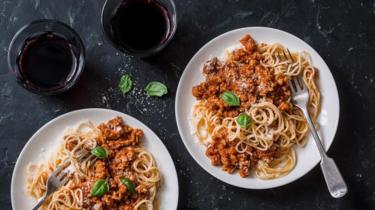 Pratos de macarrão com copos ao lado