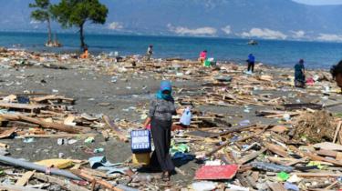 A survivor salvages useable items from debris in Palu, Indonesia's Central Sulawesi on October 1, 2018, after an earthquake and tsunami hit the area on September 28.