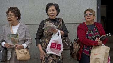 femeile sunt văzute la Liberdade, un cartier central din Sao Paulo cu o concentrație mare de descendenți japonezi, pe 14 iunie 2014.