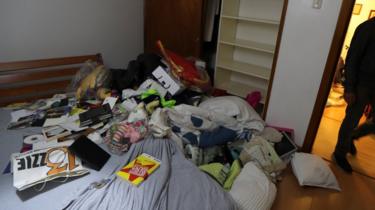 Personal belongings are seen on the floor at the residence of Roberto Marrero
