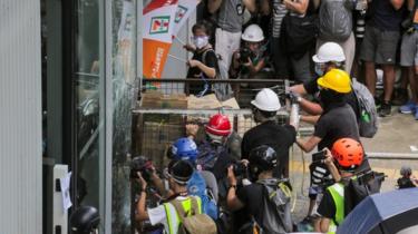 manifestantes intentan ingresar a un edificio