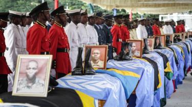 Soldiers of Tanzania People"s Defence Force (TPDF) stand beside the coffins of Tanzanian peacekeepers who were killed by by suspected Ugandan rebels, at the headquarters of Tanzania People"s Defence Force in Dar es Salaam on December 14, 2017.