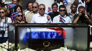 フィデル-アンヘル-カストロ-ディアス＝バラート（C）は、2月、2016年にサンティアゴ-デ-クーバのセスペデス公園で、父親の灰と骨壷を見ながら、キューバの国旗を保持している。