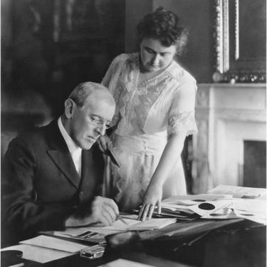 La primera dama Edith Wilson asiste al presidente Woodrow Wilson en su escritorio de la Casa Blanca, Washington DC, junio, 1920