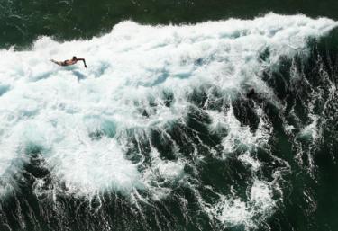 A surfer falls into a wave