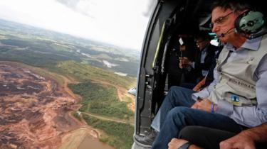 Brazilian President Jair Bolsonaro (R) as he sits inside a helicopter flying over the area affected by the dam burst near Brumadinho, Minas Gerais, Brazil, 26 January 2019
