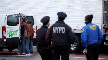 Policía al lado de los camiones llenos de cadáveres en Nueva York.