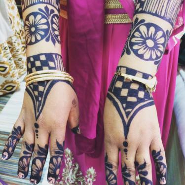 Sally's arms and hands have been decorated in advance with henna