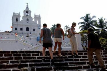 Internationale toeristen met een Indiase gids lopen de trappen op naar de Sint-Mariakerk in Panjim, de hoofdstad van het oude Goa, zo'n 615 km ten zuiden van Bombay, op 01 december 2003. Uit de laatste cijfers blijkt dat het aantal bezoekers aan India aanzienlijk is toegenomen, waarbij Goa een van de populairste bestemmingen voor toeristen is.