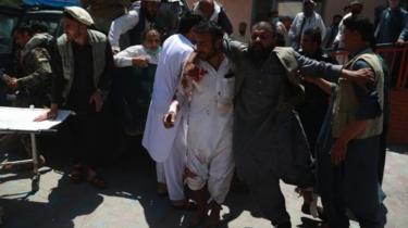 People shift injured victims of a suicide bomb attack to a hospital in Jalalabad, Afghanistan, 12 May 2020