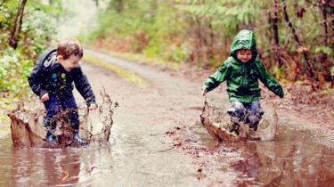 two-boys-jumping-in-kałuże