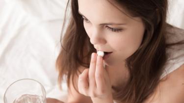 Stock image of a woman taking a tablettát