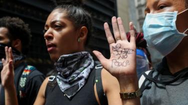 Femme à New York tenant les mains en l'air dans le cadre d'une manifestation