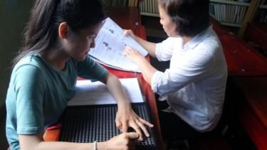 Một cô gái khiếm thị viết chữ nổi Braille