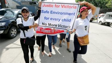 Protesters hold signs during a march demanding justice for a child rape case, in Yangon