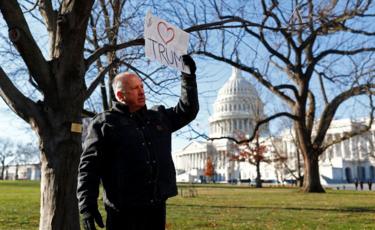 A man displays a pro-Trump sign near the Capitol on Wednesday