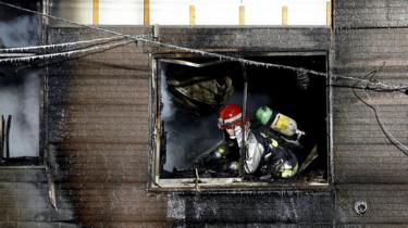 A firefighter at the burnt-out elderly home