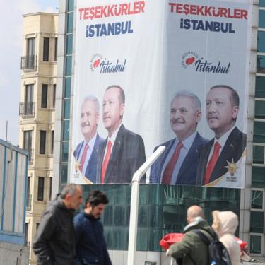 People pass in front of a huge banner with pictures of Turkish President Recep Tayyip Erdogan and Binali Yildirim, candidate of Turkish ruling party Justice and Development Party (AK Party) reading on "Thank you Istanbul" in Istanbul, Turkey, 03 April 2019