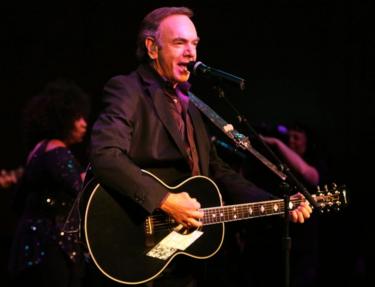 Neil Diamond fotografiado actuando con una guitarra en 2008