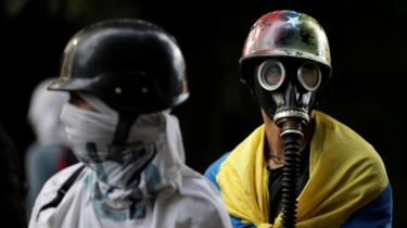 Manifestantes olhar enquanto, protestando contra o governo em Caracas, Venezuela, em 4 de agosto