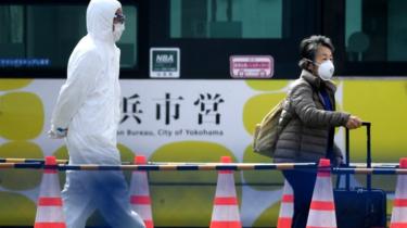 A passenger leaves the Diamond Princess cruise ship - in quarantine due to fears of the new Covid-19 coronavirus - at the Daikoku Pier Cruise Terminal in Yokohama, 19 February 2020