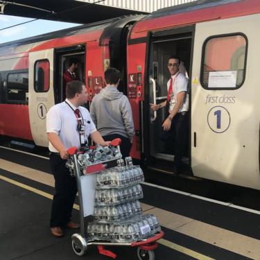 A LNER staff member pushes a trolley of bottled water at Peterborough station, as passengers wait for news during travel disruption on the East Coast mainline, after a large power cut