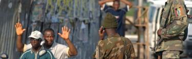 A man on a motorbike travels past soldiers with his hands in the air, in Yenagoa, Bayelsa State - 2007