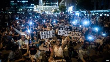 Demonstranten zitten in een straat van het centrale district na een pro-democratische rally voor meer democratie in Hongkong op 1 juli 2014.