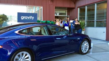 Dan Price with Alyssa O'Neal, accepting his Tesla