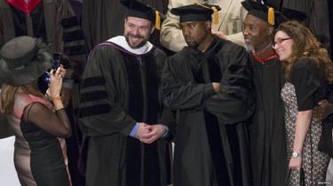 Kanye West posando para fotos después de recibir su doctorado honorario.