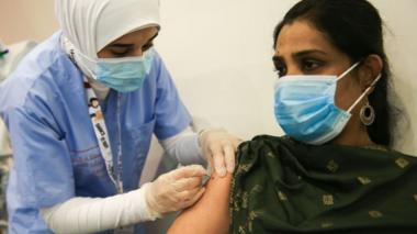 A woman is vaccinated with a syringe of a Chinese COVID-19 vaccine, developed by medicine company Sinopharm
