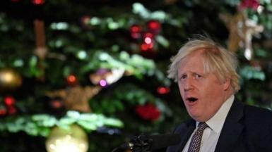 Boris Johnson next to a christmas tree
