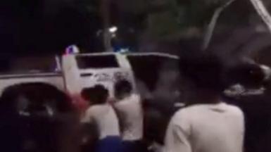 Protesters overturn a police car
