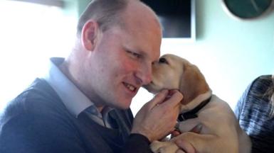 Sean Dilley with a guide dog