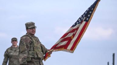 Soldier training in Poland holds American flag